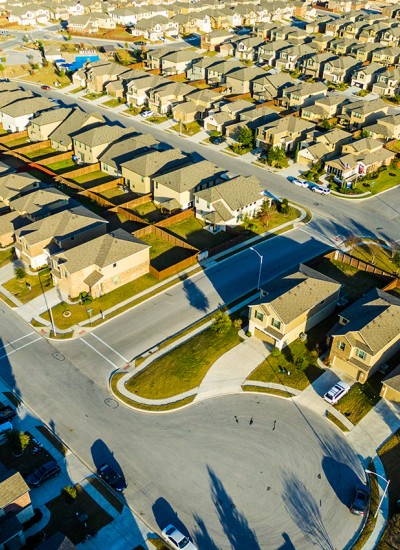 An aerial photo of cookie-cutter houses on suburban lots as far as the eye can see