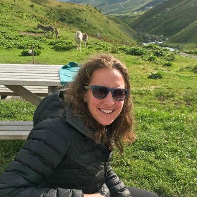 A photo of Meriel Darzen in a grassy space with picnic tables