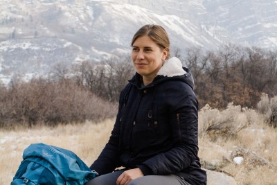 Sarah Yeoman sitting on a rock in front of a mountain