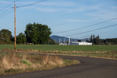 A field abutting an industrial facility shows the contrast of an urban growth boundary