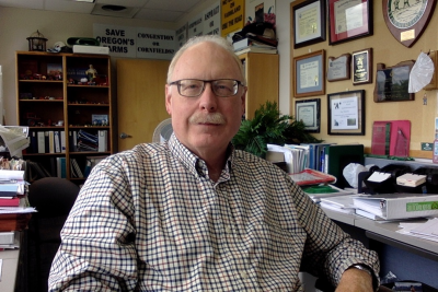 Jim Johnson sits at a desk facing the camera