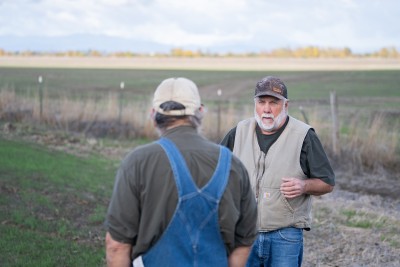 Troy Jones talks with Peter Kenagy in a field in Harrisburg