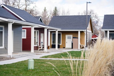 A grouping of small, colorfully painted cottages, all with their front doors facing a central lawn.