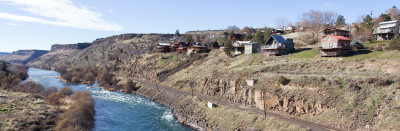 Homes atop rimrock above a river in an arid environment
