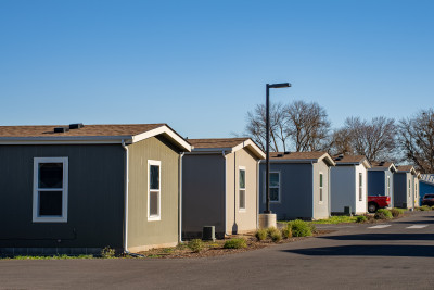 A tidy row of manufactured homes with white trim and various paint colors, in an arid environment (Talent, OR)