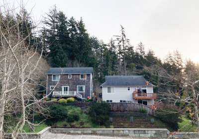 Two large homes on a forested hillside