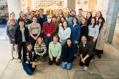 A smiling group of people outside of a building