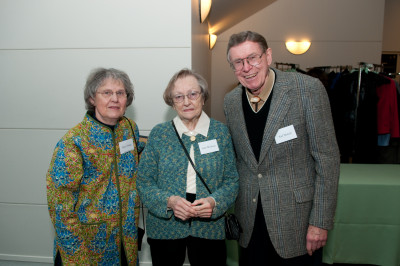 Three people wearing name tags, posing for a picture. On the left is Nancie Fadeley, wearing a bright sweater. In the middle is Janet McLennan, wearing a teal sweater. On the right is Karl Newbold, wearing a gray suit jacket over a black sweater vest and tan dress shirt.