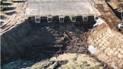 A deep pit with steep sides and six bays for waste disposal into the pit
