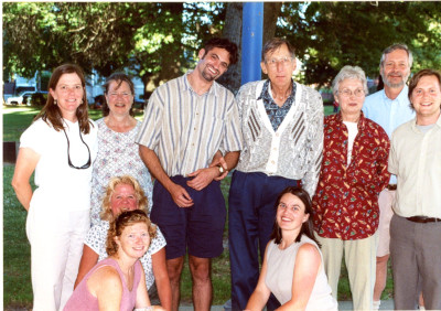 A group of people of diverse ages posing for a picture in a park