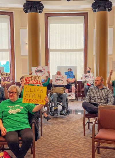 Advocates hold up signs at Portland City Hall