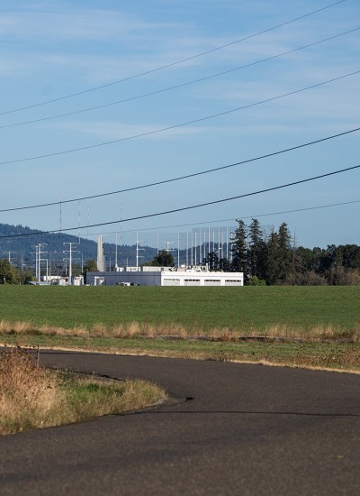 A field abutting an industrial facility shows the contrast of an urban growth boundary
