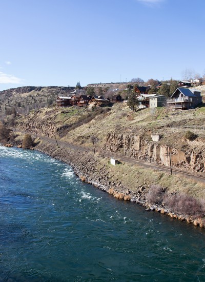 Houses on a dry grassy cliff overlooking a river