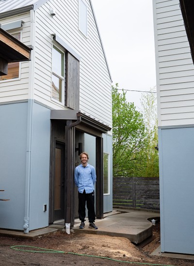 Jake Harder stands in a shared central area outside his home that's part of a cottage cluster