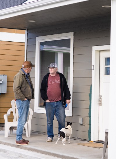 Developer Gust Tsiatsos of GCT Land Management and resident Dennis Scudder outside Dennis’ home in La Grande’s veteran village