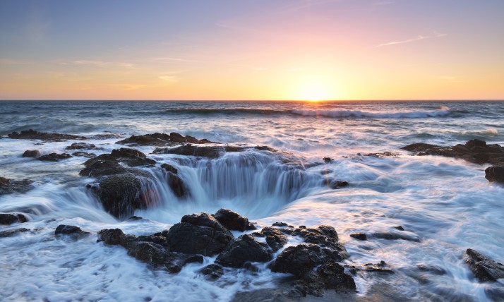 Seawater rushes into Thor's Well at sunset