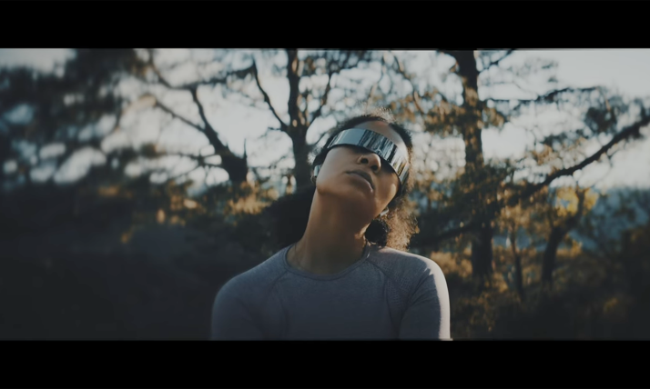 A person wears a futuristic silver visor outdoors