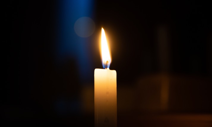 A single lit candle in a dark environment