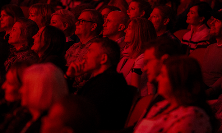 A crowd in a dimly-lit movie theater