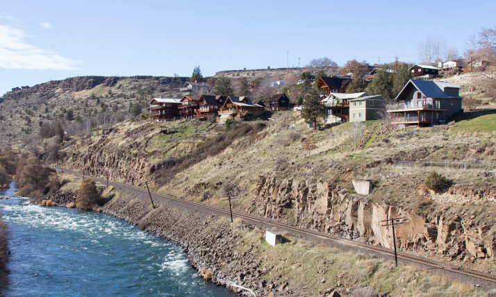 Homes atop rimrock above a river in an arid environment