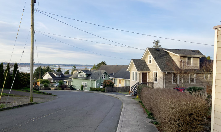 Homes on a hill sloping down to the Columbia River, with the Astoria-Megler Bridge visible.