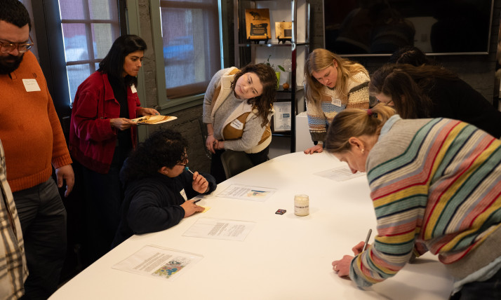 A group of people writing collaboratively on a large tabletop