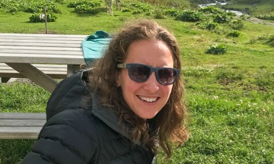 A photo of Meriel Darzen in a grassy space with picnic tables