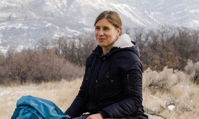 Sarah Yeoman sitting on a rock in front of a mountain