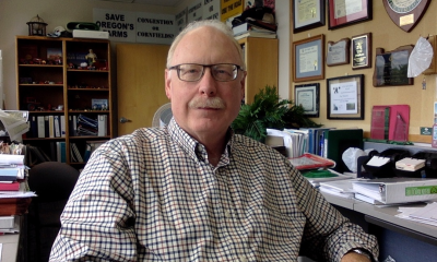 Jim Johnson sits at a desk facing the camera