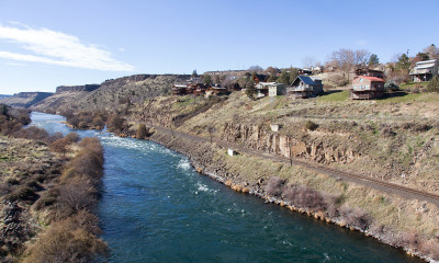 Houses on a dry grassy cliff overlooking a river