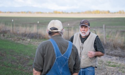 Troy Jones talks with Peter Kenagy in a field in Harrisburg