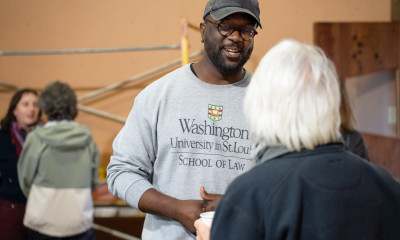 Two pairs of people talking to one another in an indoor setting