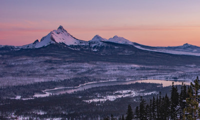 Jagged mountains rise against a colorful sunset