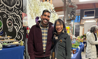 Two people smile for the camera in an indoor market