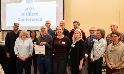 A smiling group of people, including a man with an amazing mustache who is holding a certificate for Friends of Yamhill County