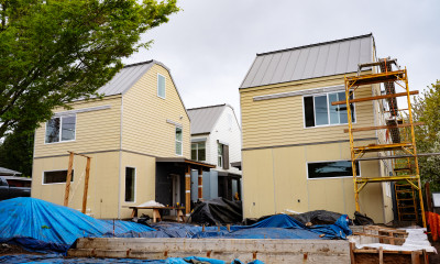 A cluster of tall, horizontally compact homes is under construction