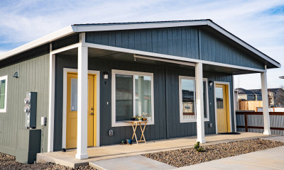 Duplex cottage with yellow doors and low, accessible ramps to the front doors (accessible senior housing in Talent, OR)