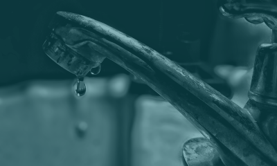 A dripping faucet in a teal-toned photo